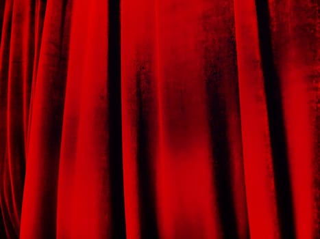Bright red abstract background reminiscent of pleats of pleasant velvet. Stylized blurred image. Background for New Year, Christmas and Valentine's Day.