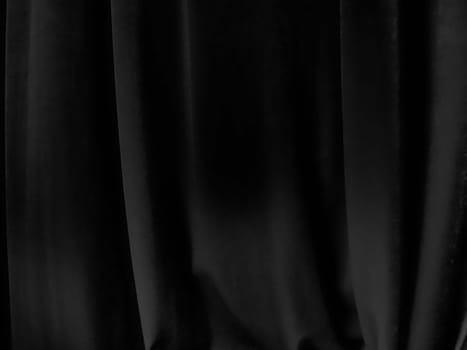 Soft waves on black velvet curtains. Stylized defocused image. Dark draperies made of pleasant fabric. Pleats on the curtains. Abstract black and gray background