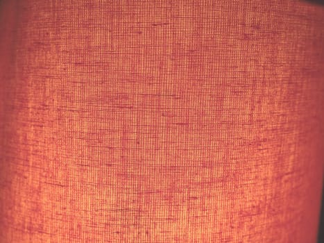 rough linen or cotton fabric with a texture of delicate red, pinkish or peachy color, grain plan. heterogeneous abstract background.