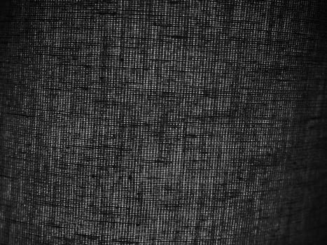background of black linen or cotton fabric with coarse threads. Abstract background. A piece of fabric with an uneven surface in a dark gray color. Interlacing of threads.