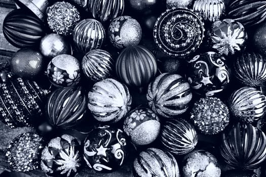 Christmas flat lay with Xmas decorations and holiday beautiful balls. Christmas tinsel. Happy New Year and Merry Christmas. Black and white monochrome photo with blue filter. Still life background.