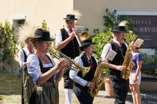 Members of the brass band Dürnstein in traditional costumes during a procession on Corpus Christi in front of the castle in Dürnstein