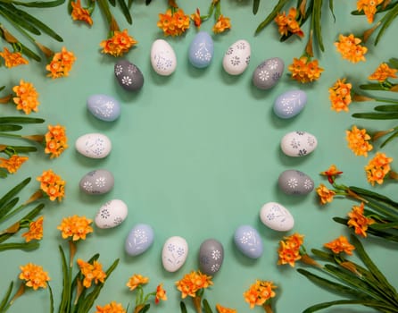 Flat Lay With Copy Space For Free Text. Easter Egg Decoration With Orange Spring Flowers. Light Green Paper Background.