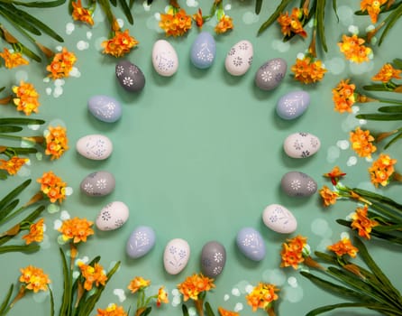 Flat Lay With Copy Space For Free Text. Easter Egg Decoration With Orange Spring Flowers. Light Green Paper Background With Bright And Shiny Light Effect.