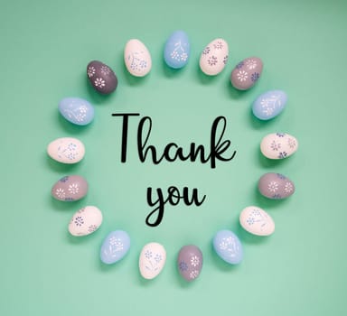 Flat Lay With English Text Thank You. Easter Egg Arrangement, Decoration And Ornament. Light Green Paper Background