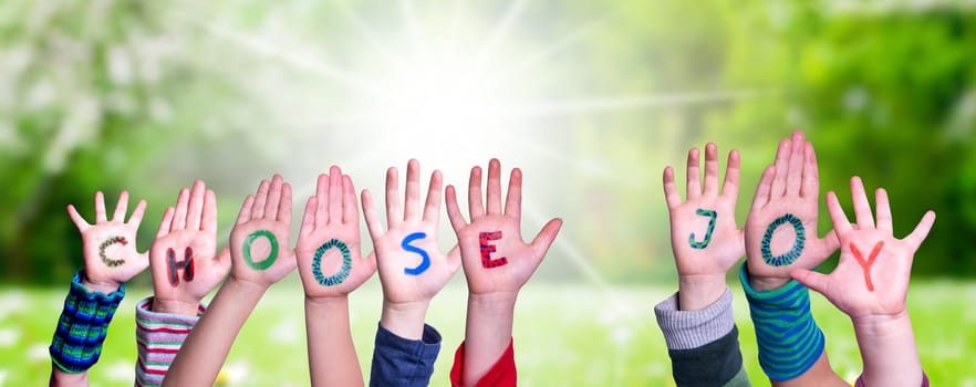 Children Hands Building Colorful English Word Choose Joy. Sunny Green Grass Meadow As Background.
