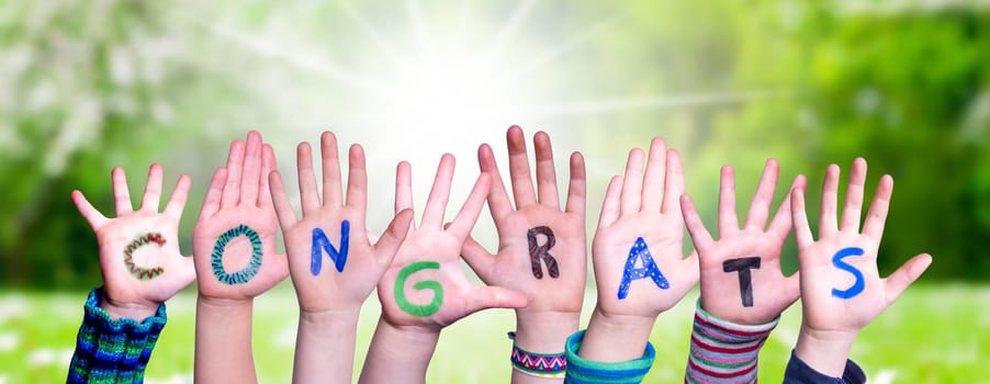 Children Hands Building Colorful English Word Congrats. Sunny Green Grass Meadow As Background.