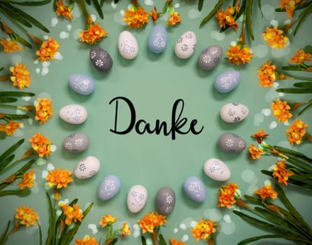Flat Lay With German Text Danke Means Thank You. Easter Egg Decoration With Orange Spring Flowers. Light Green Paper Background With Bright And Shiny Light Effect.