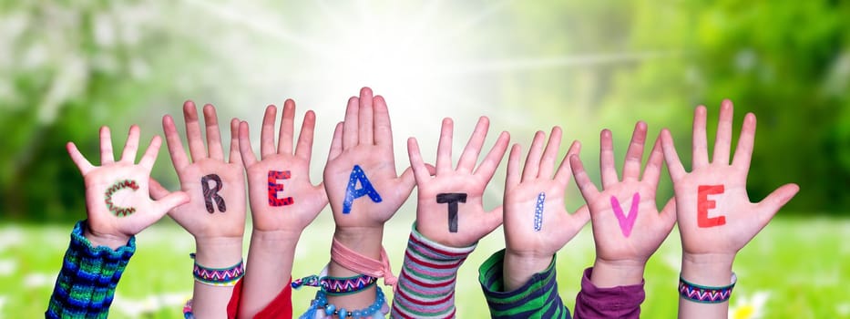 Children Hands Building Colorful English Word Creative. Sunny Green Grass Meadow As Background.
