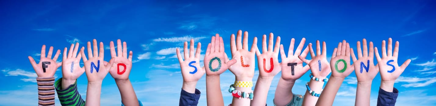 Children Hands Building Colorful English Word Find Solutions. Blue Sky As Background