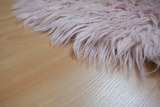 Long pile rug in pink on a beige laminate floor. Feminine interior for a room or bedroom of a girl or woman. Interior design in pink tones. Flooring is laminate. The role of dust mites in allergies