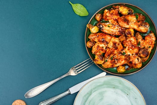 Roasted chicken wings with vegetables. Traditional baked barbecue