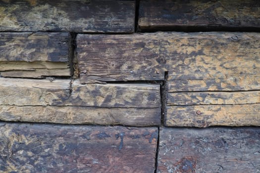 Background horizontal logs. Wooden background from shabby boards and logs. General purpose lumber. Special type of forest products. Old sleepers.