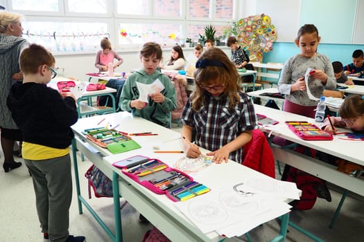 Children 9-10 years old, boys and girls, make homemade crafts at the lesson. Modern standards of education, development of creative abilities and fine motor skills at school April 9, 2022 Serbia, Srem
