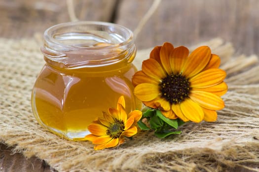 honey and flowers on wooden  background