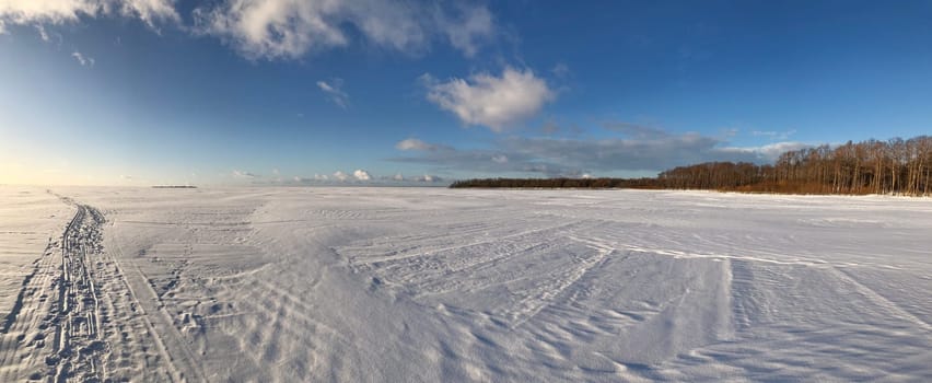 panorama frozen snow white lake, ski track, blue sky, sunny day, landscape