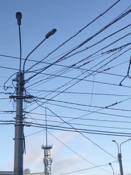pole with many electric wires in the city sky