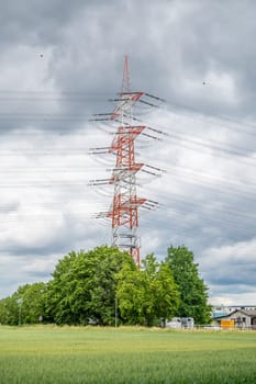 Electricity Pylon stripes white and red, view from low angle during cloudy day