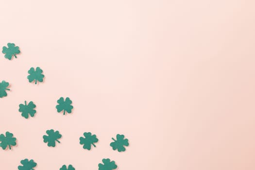 Happy St Patricks Day decoration background. above top view of paper clover leaves festive decor, shamrocks leaves holiday symbol with copy space on colour background, Banner greeting card concept
