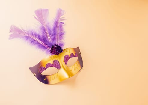 Happy Purim carnival decoration. Jewish Purim and Mardi Gras in Hebrew, Top view venetian ball mask with purple feather on pastel background, holiday background banner design, Masquerade party