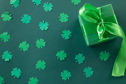 Happy St Patricks Day decoration background concept. shamrocks leaves holiday symbol with copy space on green background, above view gift box green clover leaves