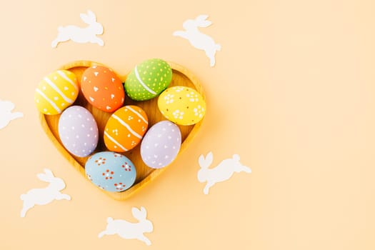 Overhead easter eggs with rabbit paper cut in shape heart isolated on pastel background, Funny decoration paper round blank, Happy Easter Day greeting card, composition banner web design holiday