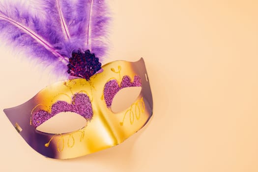 Happy Purim carnival decoration. Top view venetian ball mask with purple feather on pastel background, Jewish Purim and Mardi Gras in Hebrew, holiday background banner design, Masquerade party