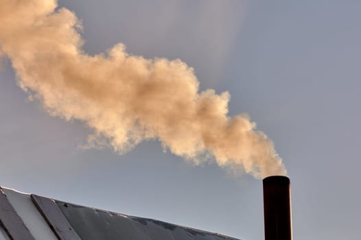 smoke is coming from the chimney of the bourgeoisie. the stove is being heated. High quality photo