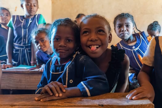 Vohitsaoka, Ambalavao, Madagascar - November 17. 2022: Happy Malagasy school children students in classroom. School attendance is compulsory, but many children do not go to school.
