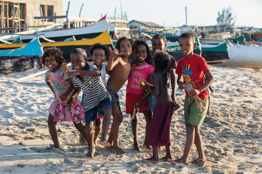 Anakao, Madagascar - November 21. 2022 - Group of Malagasy children frolicking on the beach near the fishing village of Anakao.