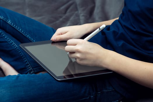 Cropped male hands working with digital pad, tablet with stylus pen technology, online and wireless service. Graphic designer working with internet. E-learning and trading, freelance remote job