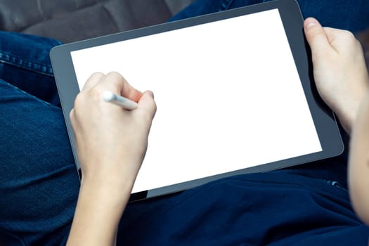 Unrecognizable male hands drawing with stylus pen on digital tab, pad touchscreen with white screen on knees. Web technology and app for artists, creative occupation online. High angle, above shoulder