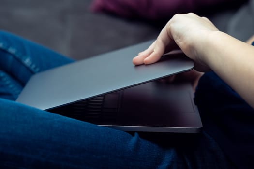 Unrecognizable male hands opening laptop cover on knees. Portable wireless device, business and remote job, trading and freelance occupation. E-learning and online school, web application work