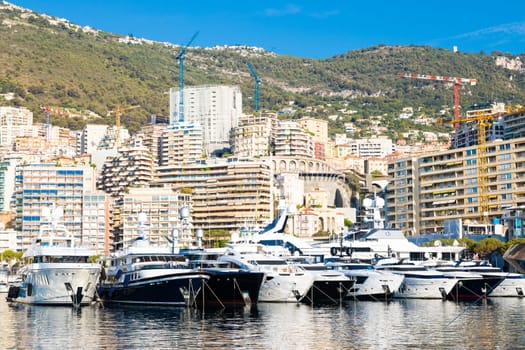Monte Carlo, Monaco - August 2022: Port Hercule with luxury yachts,  boats, and scenery skyline