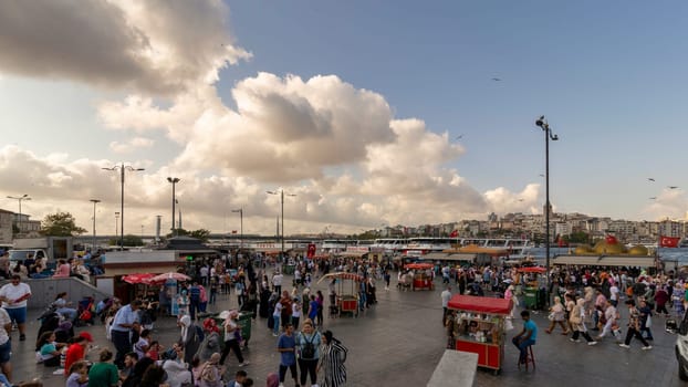 Istanbul, Turkey - August 30, 2022: Crowds of local citizens at Eminonu Plaza during the Victory Day holiday with background of Istanbul city view