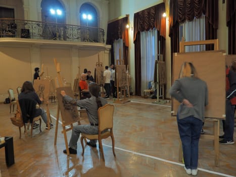 Sremska Mitrovica, Serbia May 15, 2021. Painters and easels. People and students paint from nature. Museum Night. Workshop with youth. Visual arts. Large hall with windows, curtains and lambrequins
