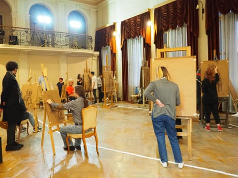 Sremska Mitrovica, Serbia May 15, 2021. Painters and easels. People and students paint from nature. Museum Night. Workshop with youth. Visual arts. Large hall with windows, curtains and lambrequins