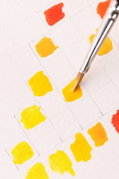 Brush painting orange watercolor swatch on paper