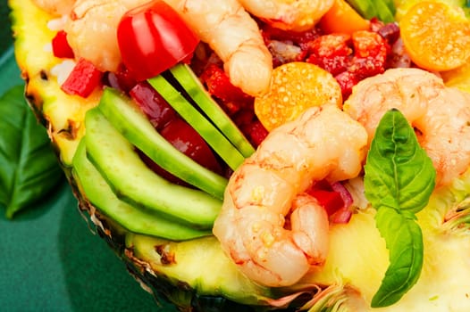 Half a pineapple with vegetables, rice and seafood on a white plate. Salad
