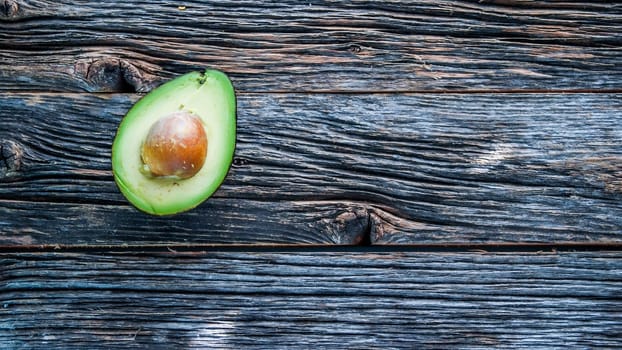 Avocado on rustic wooden table with copy space