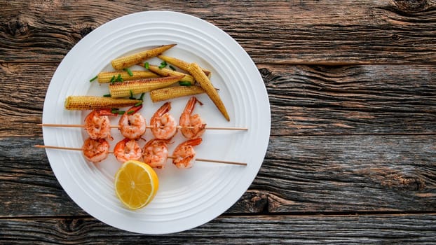 Close up from shrimps with baby corn on white plate  from above