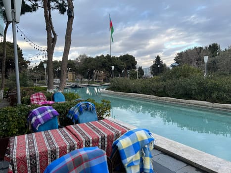 park with pool and azerbaijan flag waving in cloudy weather