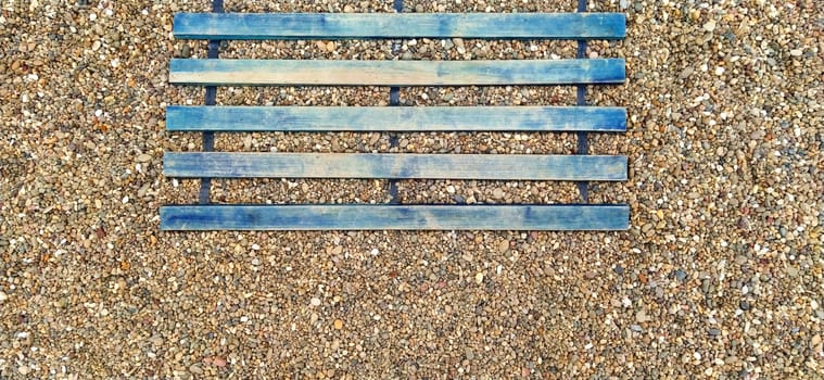 Wooden boardwalk on the beach. Sticks and boards on rocky ground. Heel protection from damage. Summer time and beach holidays. Travel and tourism concept