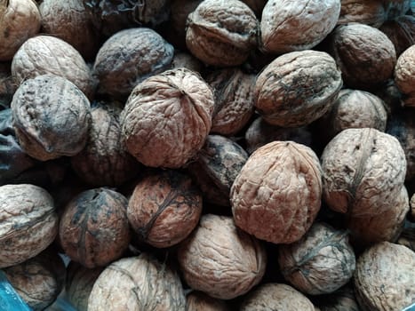 Walnuts close-up. Harvest of nuts. Walnut fruits, rounded large single single-seeded drupes. A healthy diet that includes glycerides of linoleic, oleic, stearic, palmitic and linolenic acids.