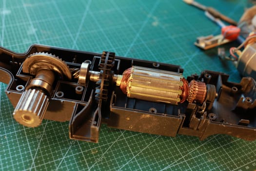 power tool dismantled for repair, electric motor rotor, gear