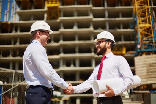 Two architects congratulating one another on striking deal
