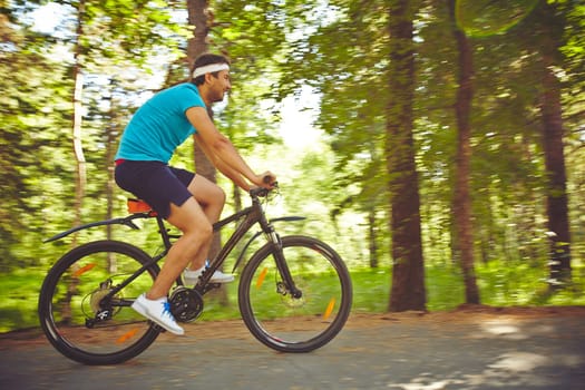 Young sportsman riding bicycle in park