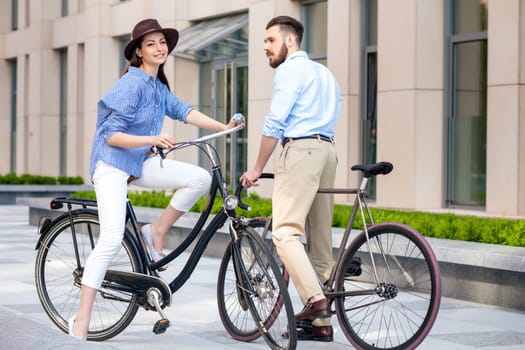 Romantic date of young couple on bicycles at street