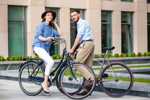 Romantic date of young couple on bicycles at street