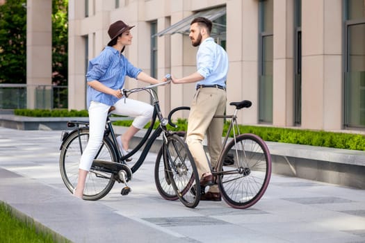 Romantic date of young couple on bicycles at street